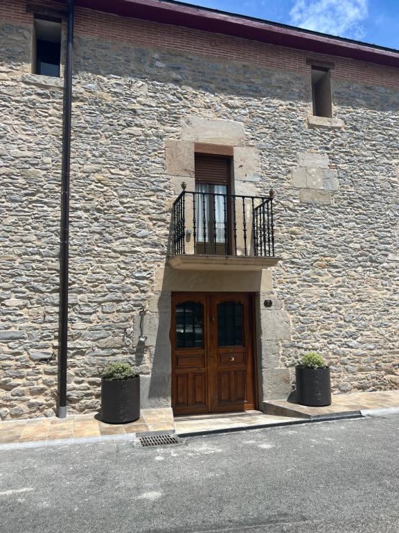 a building with a wooden door and a balcony at Hostel el jardin in Gamarra Mayor