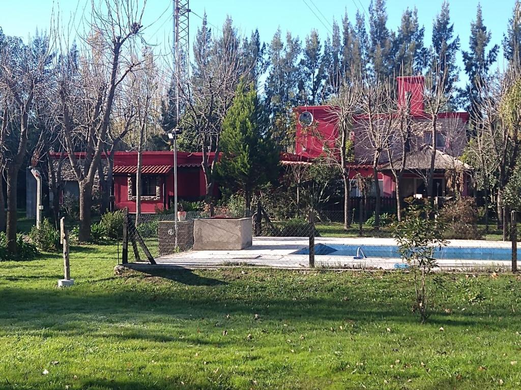 una casa con un patio con un columpio en el césped en Hotel y Casa de Campo Oasis Campero Ezeiza -San Vicente en San Vicente