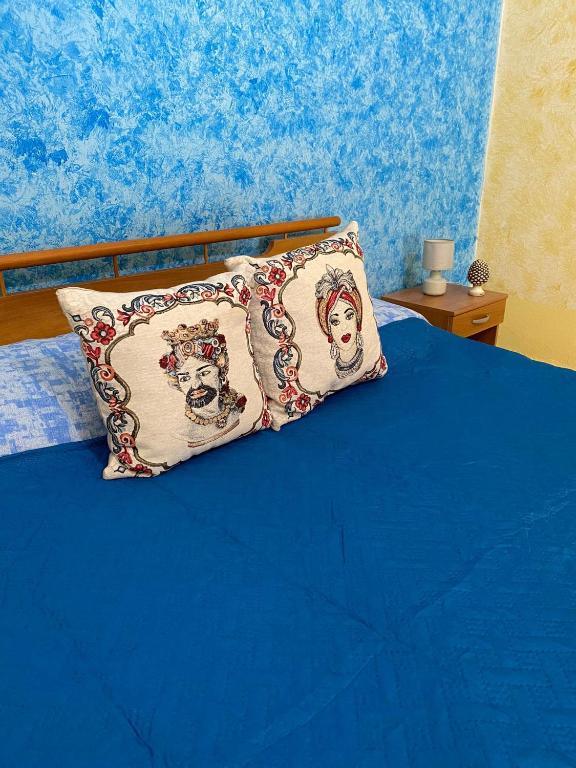 uma cama azul com uma almofada em cima em Nora Home em Avola