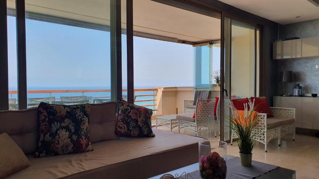 - un salon avec un canapé et une vue sur l'océan dans l'établissement Prestigia bouknadel, à Sidi Bouqnadel