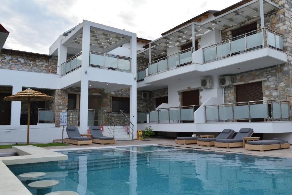 a villa with a swimming pool and a building at Dioscuri Deluxe Apartments in Chrysi Ammoudia