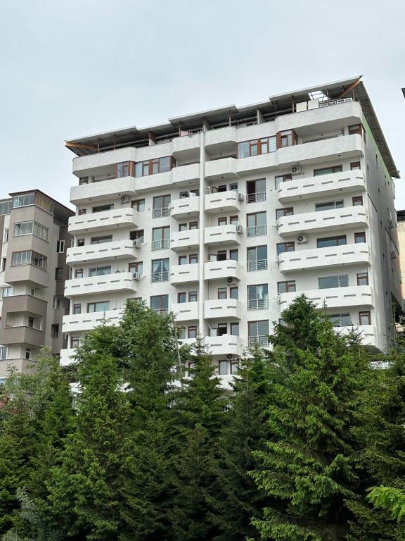 um edifício alto e branco com árvores em frente em Shah Residence Hotel em Bostancı