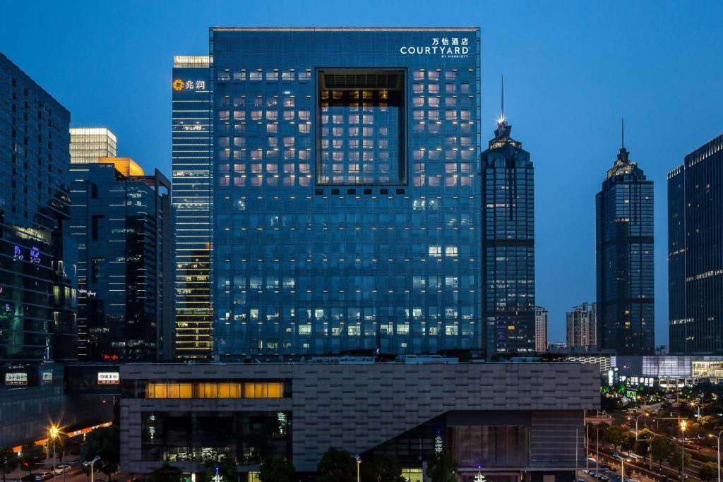 um edifício alto numa cidade à noite em Courtyard by Marriott Suzhou em Suzhou