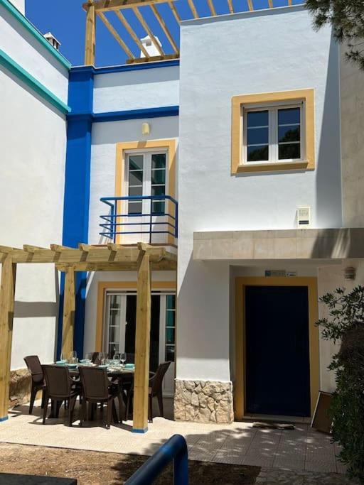 a house with a table and chairs in front of it at Moradia V3 na Urbanização Praia Verde in Praia Verde