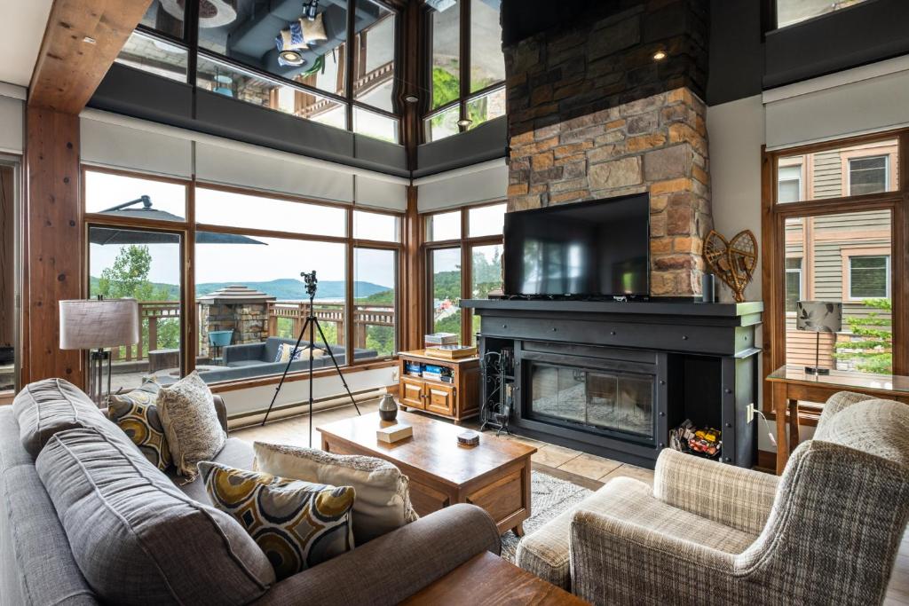 uma sala de estar com sofás e uma lareira em Tremblant Prestige-Altitude 170-1 em Mont-Tremblant