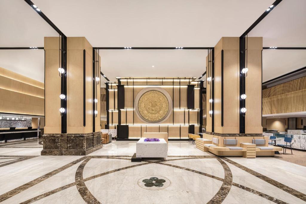 a lobby of a hotel with couches and a table at Sheraton Nanjing Kingsley Hotel & Towers in Nanjing