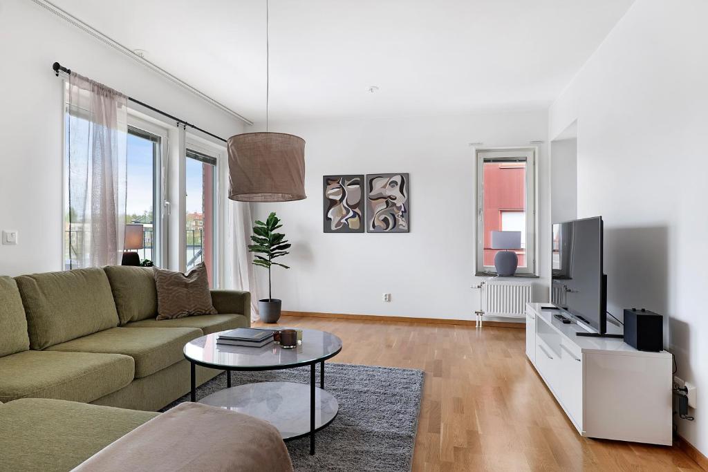 uma sala de estar com um sofá e uma televisão em Guestly Homes - 3BR Modern Apartment em Pitea