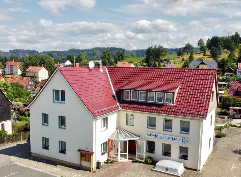 eine Luftansicht eines weißen Hauses mit rotem Dach in der Unterkunft Gästehaus Kaiserkrone in Schöna