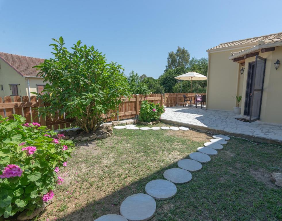 a backyard with a garden with a stone path at Saralen cottage in North Corfu 