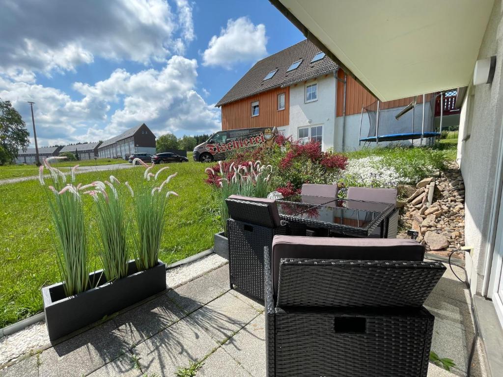eine Terrasse mit 2 Stühlen und einem Tisch und einigen Pflanzen in der Unterkunft Ferienwohnung Augenblick in Kurort Altenberg