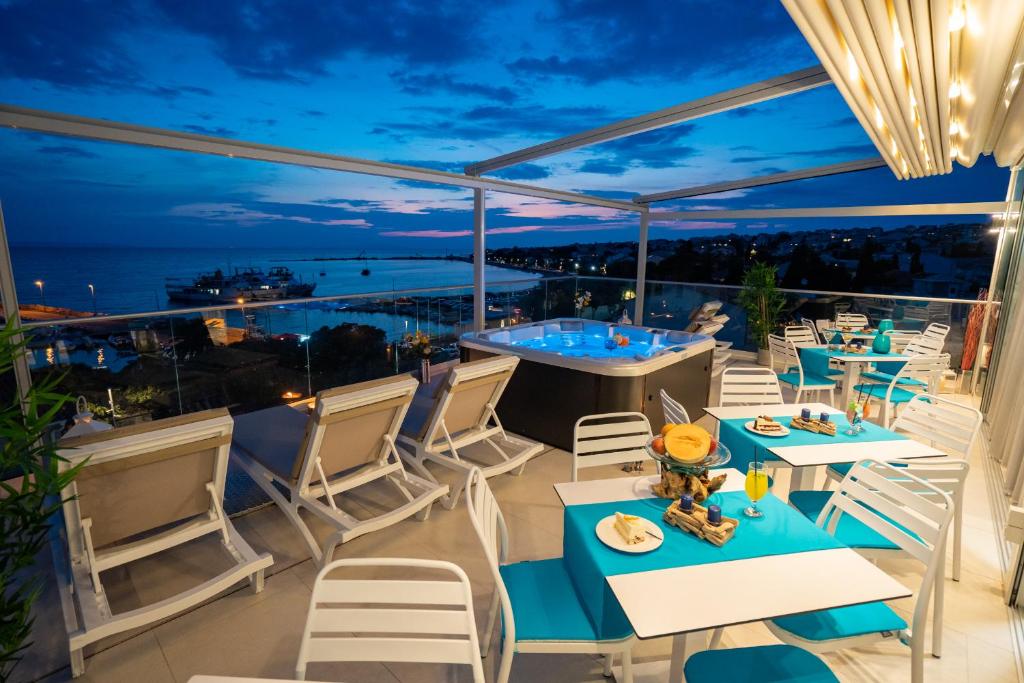 a balcony with tables and chairs and a view of the ocean at Bed&Breakfast Novalis in Novalja