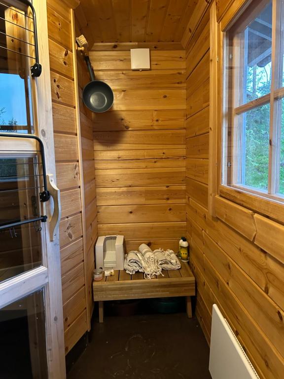 Sauna cabin in the heart of Nuuksio National Park - Mökki Nuuksiossa في إسبو: ساونا مع مقعد في غرفة خشبية