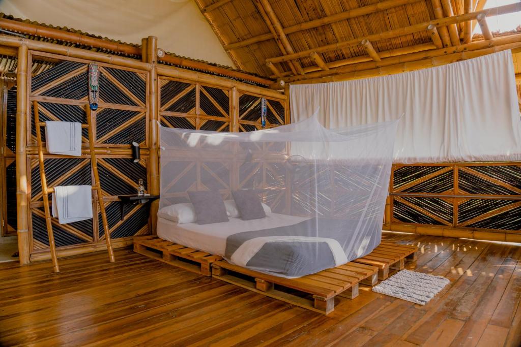 a room with a bed with a net at Niuwi Hostel in Buritaca