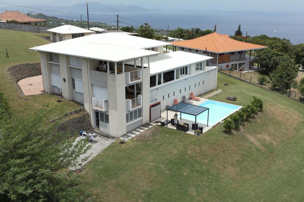 an overhead view of a white house with a swimming pool at Villa Maxim vue sur mer in Fond Boucher