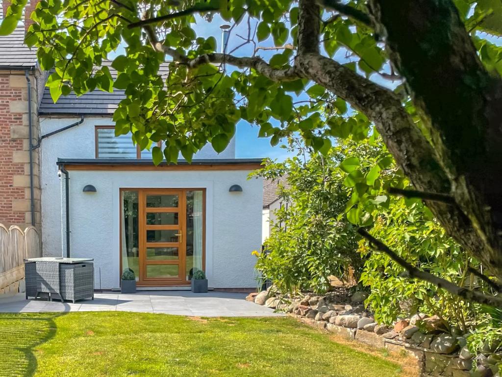 a house with a wooden door in a yard at Townend Cottage in Aikton