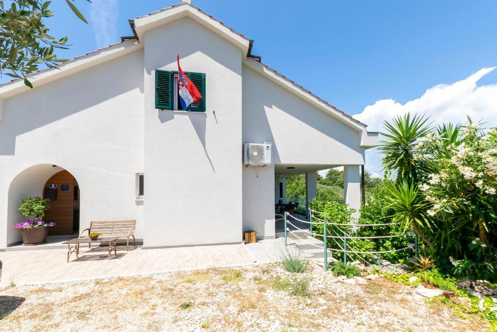 a white church with a sign on the side of it at Apartment Sweet Dream Manjiga in Nečujam