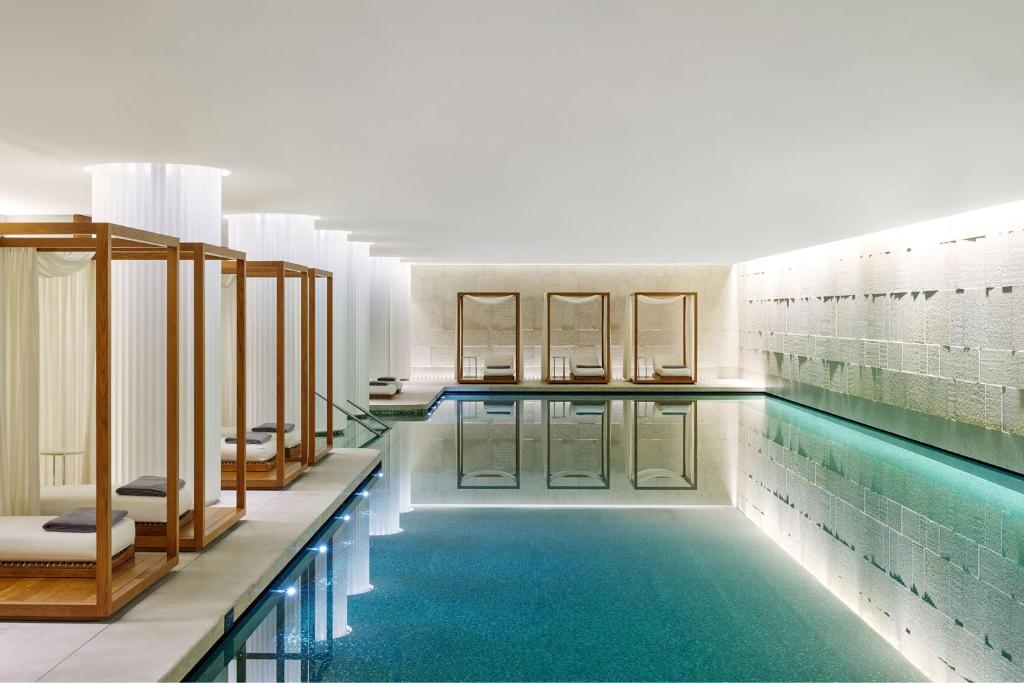 a swimming pool with blue water in a building at Bulgari Hotel London in London