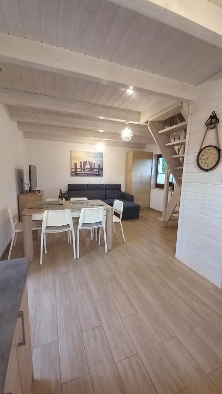 uma sala de estar com uma mesa e cadeiras e um sofá em Pokoje I Domki WIKTORIA em Będzino