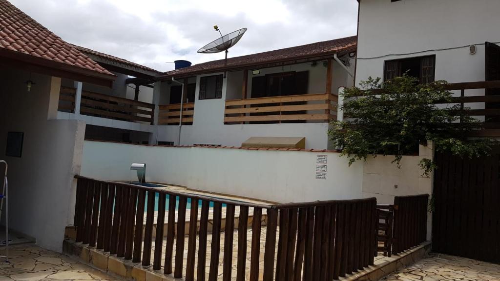 a house with a wooden fence in front of it at Recanto Vizinho do Mar in Ubatuba