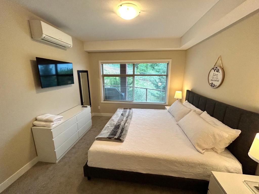 a bedroom with a large bed and a window at Stay In The Okanagan - Copper Sky, West Kelowna in West Kelowna