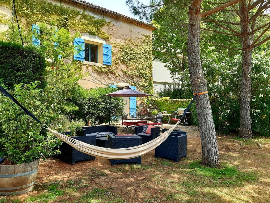 a hammock in a yard next to a house at Magnifiques maisons de campagne au sein d&#39;un vignoble in Cazouls-lès-Béziers