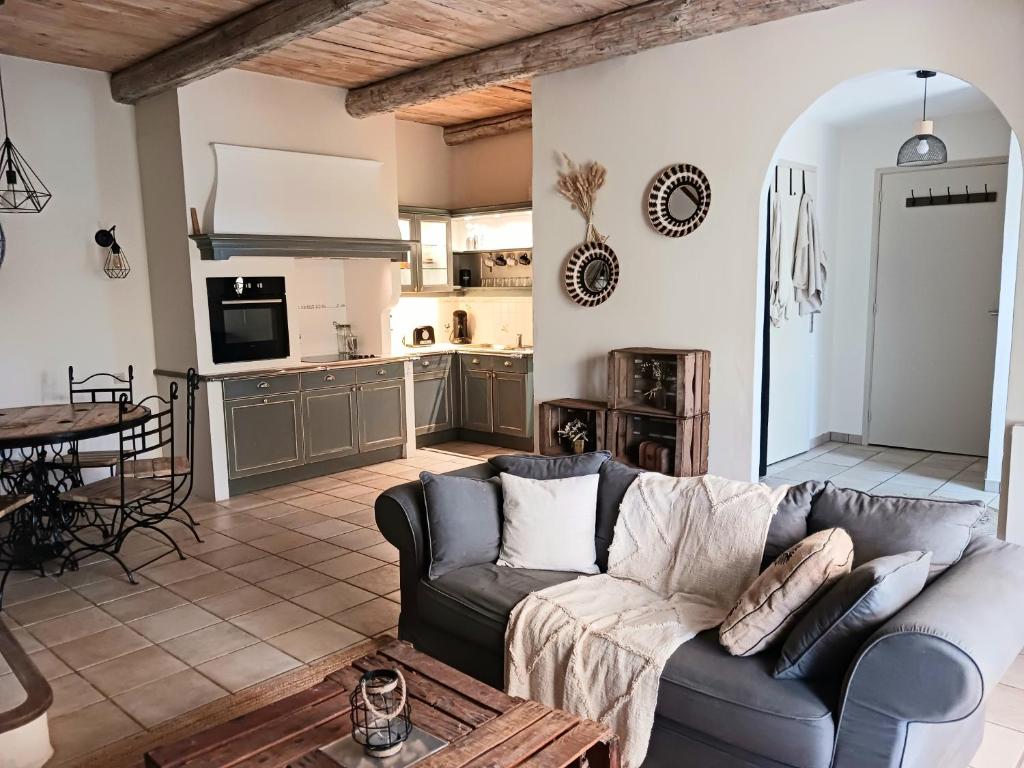 a living room with a couch and a kitchen at Magnifiques maisons de campagne au sein d&#39;un vignoble in Cazouls-lès-Béziers