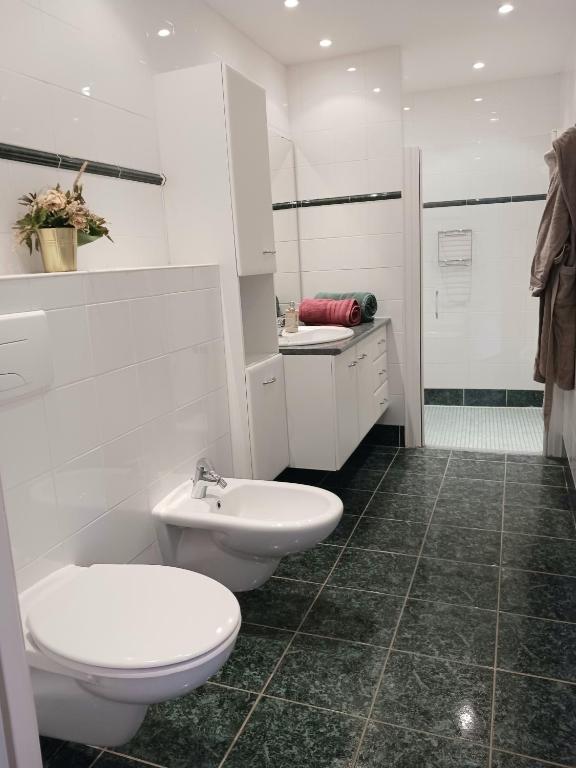 a white bathroom with a toilet and a sink at Magnifiques maisons de campagne au sein d&#39;un vignoble in Cazouls-lès-Béziers