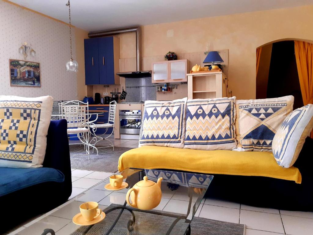 a living room with a couch and a kitchen at Magnifiques maisons de campagne au sein d&#39;un vignoble in Cazouls-lès-Béziers
