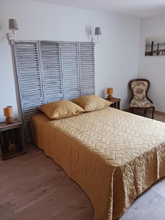 a bedroom with a large bed and two chairs at Magnifiques maisons de campagne au sein d&#39;un vignoble in Cazouls-lès-Béziers