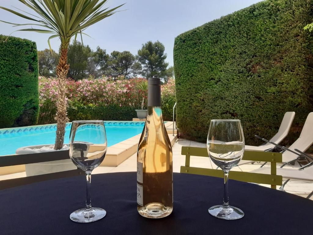 a bottle of wine and two glasses on a table at Magnifiques maisons de campagne au sein d&#39;un vignoble in Cazouls-lès-Béziers