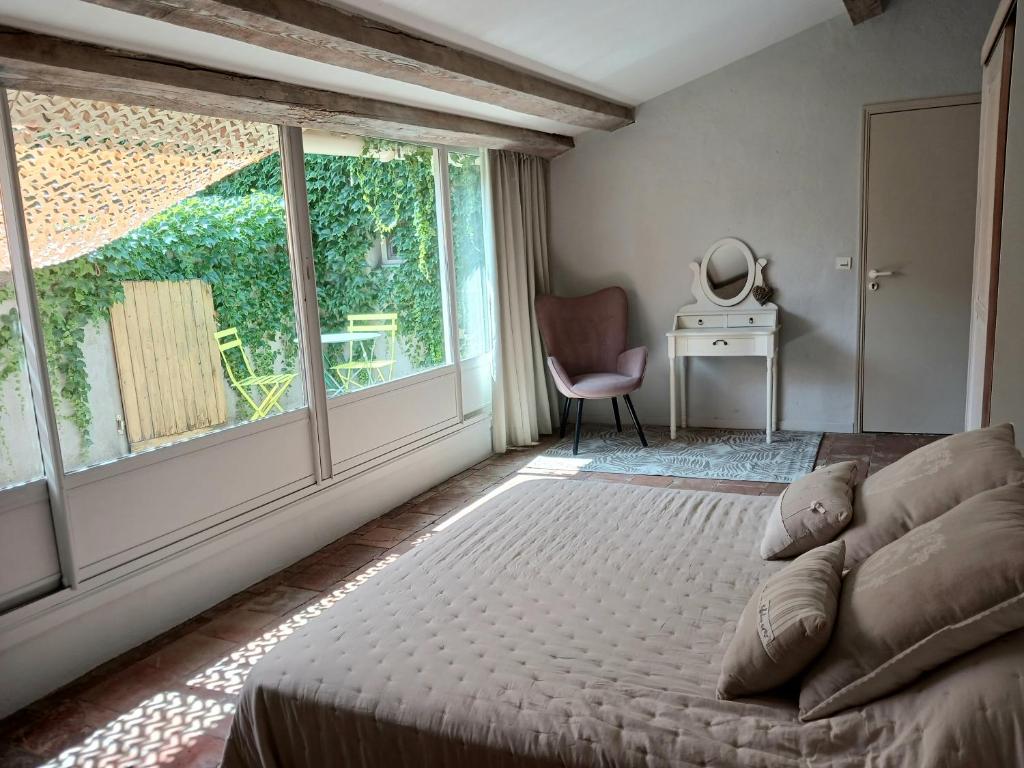 a bedroom with a bed and a large window at Magnifiques maisons de campagne au sein d&#39;un vignoble in Cazouls-lès-Béziers