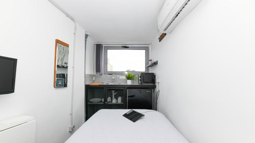 Kleines weißes Zimmer mit einem Bett und einem Waschbecken in der Unterkunft Monastiraki City Sleepbox- Unspoiled Athens Apartments in Athen