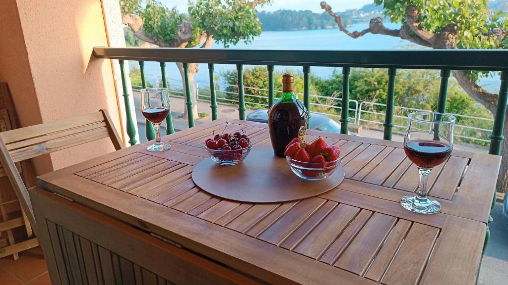 uma mesa com uma garrafa de vinho e dois copos em SALSEIRAZO - PLAYA A RIBEIRA MIÑO em Miño
