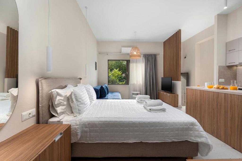 een slaapkamer met een groot bed en een keuken bij Ble Residence, Your Home Away from Home in Panormos Rethymno
