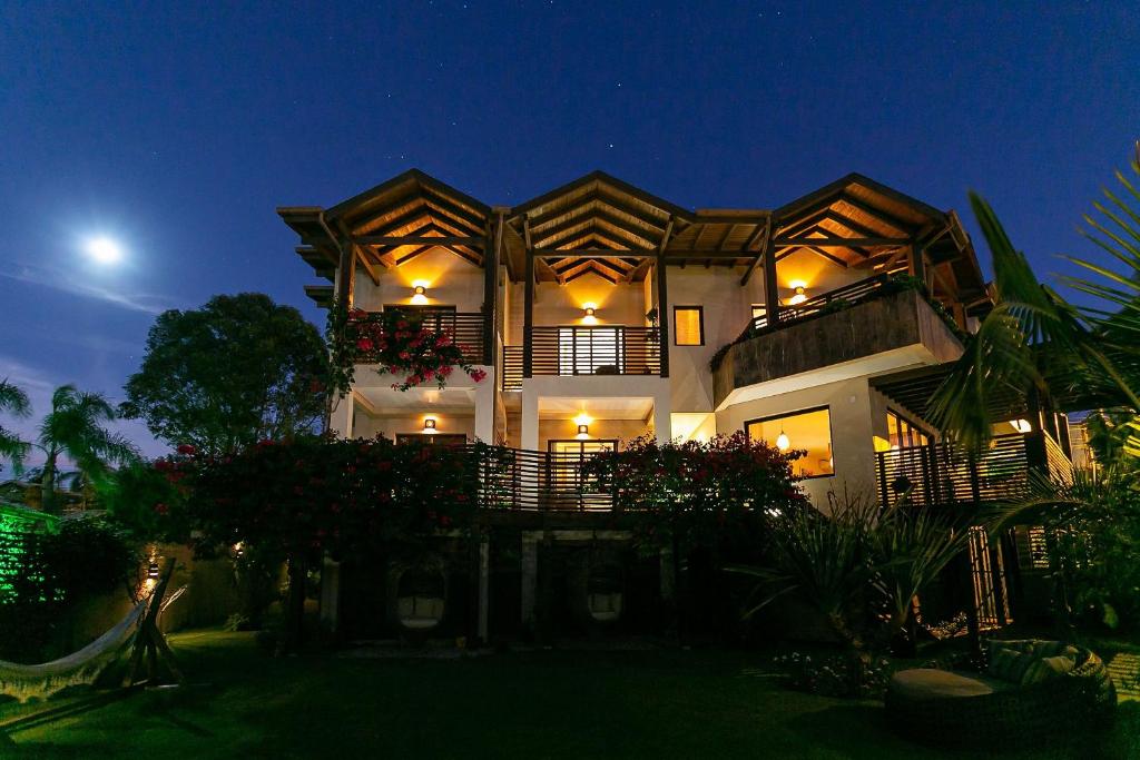 Shiva Boutique Hotel - Praia do Rosa في برايا دو روزا: منزل كبير في الليل مع القمر في السماء