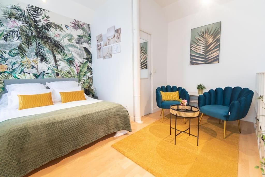 - une chambre avec un lit et deux chaises bleues dans l'établissement Magnifique duplex à 2min du RERB, à Gentilly