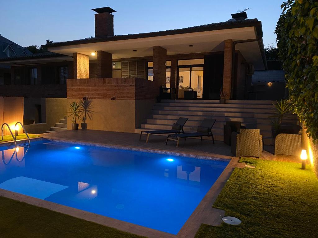 a swimming pool in front of a house at night at Villa Fontpi in Pallejá
