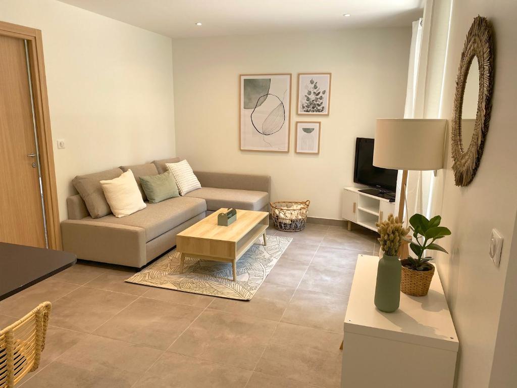 un salon avec un canapé et une table basse dans l'établissement T2 Neuf, parking & garage privé, proche centre, à Sarlat-la-Canéda