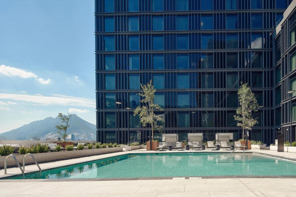 a swimming pool in front of a tall building at JW Marriott Hotel Monterrey Valle in Monterrey