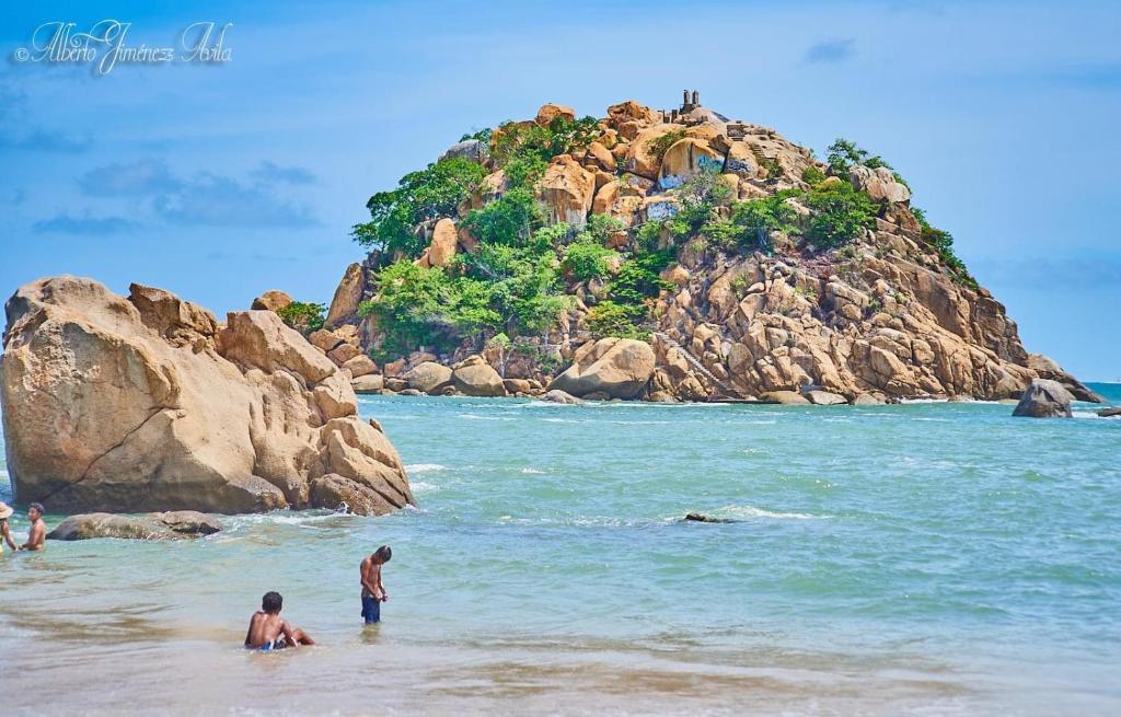 un grupo de personas de pie en el agua en una playa en Cómodo y muy relajante alojamiento a 5 minutos de la playa, en Acapulco