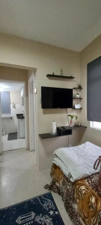 um quarto com uma cama e uma televisão de ecrã plano em apto bem localizado todo mobiliado em Foz do Iguaçu