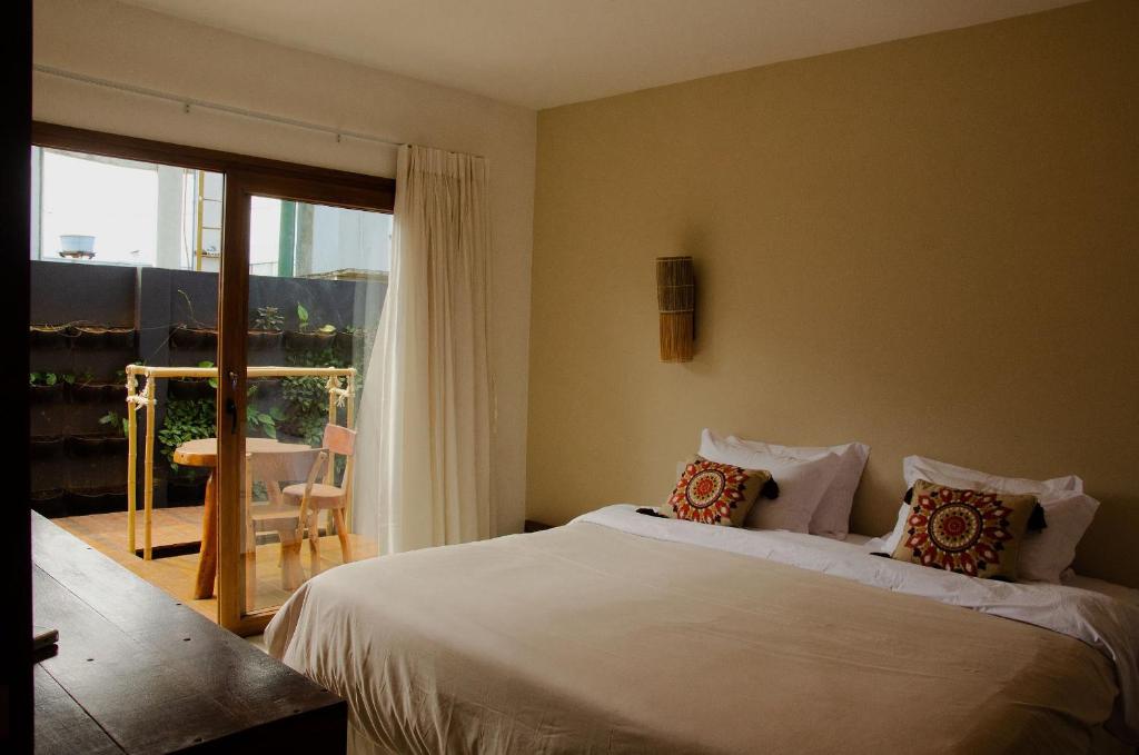 um quarto com uma cama e uma porta de vidro deslizante em Casa Makaira em Fernando de Noronha