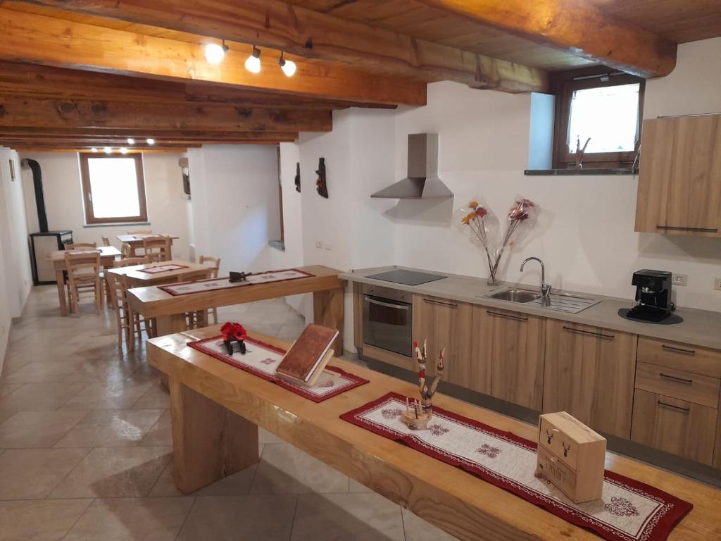 a large kitchen with wooden cabinets and a table at Bed & Breakfast La Crotta in Pont-Saint-Martin