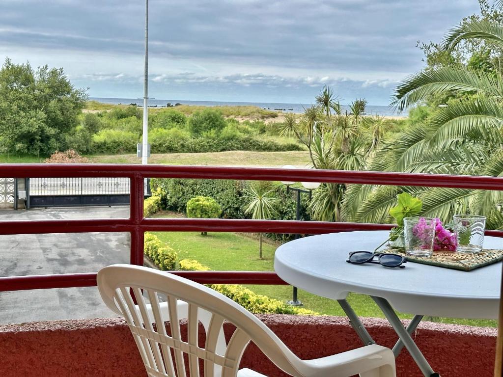 una mesa y sillas en un balcón con vistas al océano en Los Campizos - 6619, en Noja
