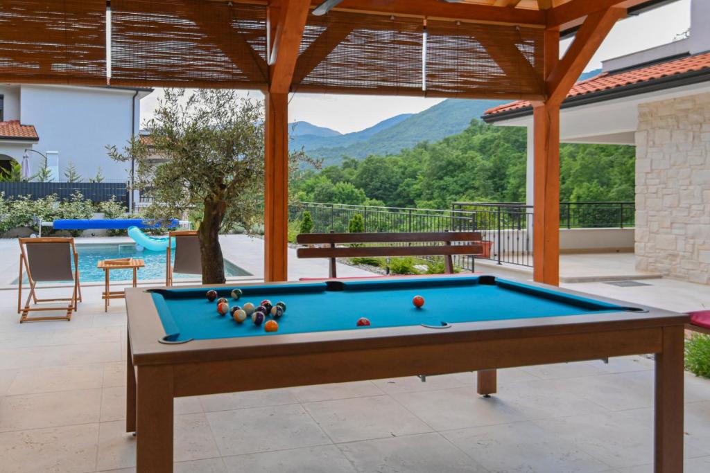 a pool table in the middle of a patio at Villa Suzana grijani bazen i biljar na otvorenom in Veprinac