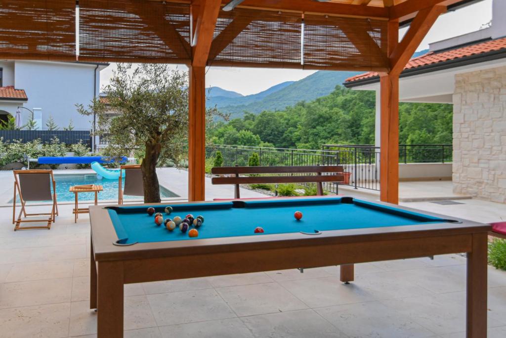 einen Billardtisch in der Mitte einer Terrasse in der Unterkunft Villa Suzana grijani bazen i biljar na otvorenom in Veprinac