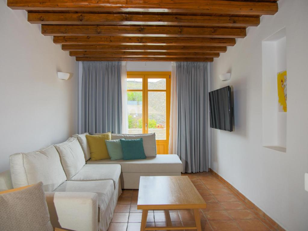 a living room with a white couch and a table at Bella Resorts Andros in Andros