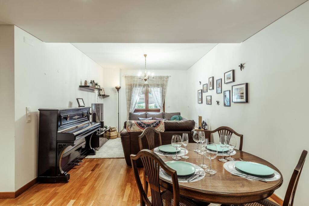 uma sala de jantar com uma mesa e um piano em Charmoso Apartamento Sacavém em Sacavém