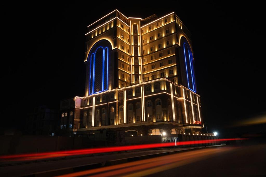 a large building with blue lights on it at night at Move npic Zenat al Hayat Hotel in Al Başrah