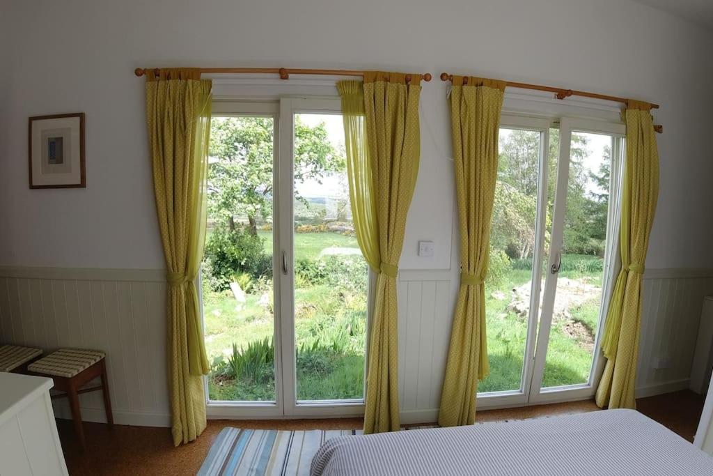 a bedroom with a large window with yellow curtains at Innisfreedom cabin in Sligo